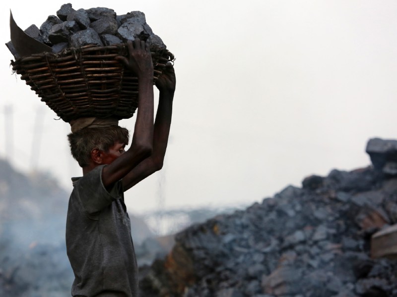 An Indian coal mine worker carries a basket of coal collected at a mine in the district of Dhanbad in the state of Jharkhand in June 2017. Photo: AFP/Sanjib Dutta